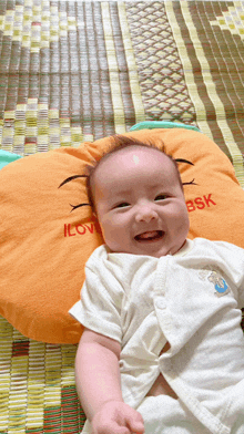 a baby laying on a pillow that says i love bsk on it