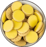 a bowl of baby crackers with yellow icing on them