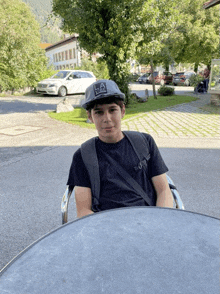 a young boy wearing a la hat sits at a table outside