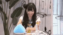 a girl in a sailor uniform is sitting at a table with a bottle of water