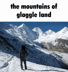 a man is standing on top of a snow covered mountain with the words the mountains of glaggle land above him .