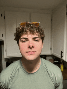 a young man wearing sunglasses and a green shirt