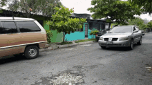 a silver car with a license plate that says ' a ' on it is parked on the side of the road