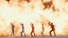 a group of power rangers are standing in front of a large fire