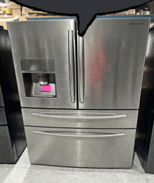 a stainless steel samsung refrigerator with a pink sticky note on it