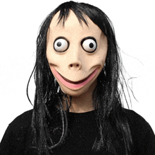 a woman wearing a momo mask with big eyes and a smile on her face