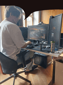 a can of long strong sits on a desk next to a man using a computer