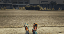 a person 's feet are on a sidewalk in front of a building that says bawdaq