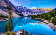 a lake surrounded by mountains and trees with a reflection of the mountains in the water