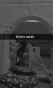 a girl is taking a selfie in front of a mirror with ekdom baddie written on the bottom