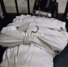 a person in a straitjacket is laying on a bed with the words " fit check " above them