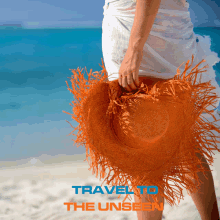 a woman holding an orange hat on the beach with travel to the unseen written on the bottom