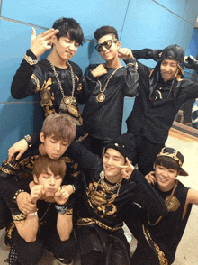 a group of young men are posing for a picture and one of them is wearing a black shirt with a gold lion on it