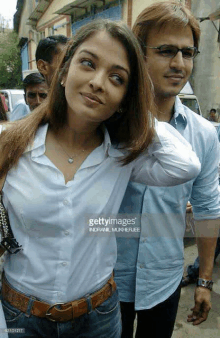 a man and a woman are standing next to each other in a crowd .