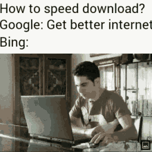 a man is sitting at a table using a laptop computer with the caption how to speed download google : get better internet bing :