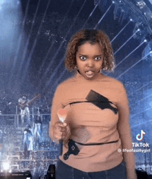 a woman wearing a shirt with combs on it is holding a brush and pointing at the camera .