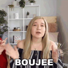 a blonde woman says boujee in front of a shelf