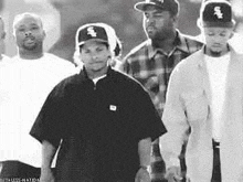 a group of men are standing next to each other wearing baseball caps .