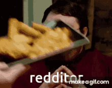 a man is eating french fries with a knife and the words reddit make a gif.com are on the bottom