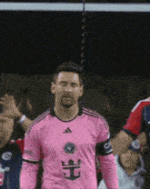 a soccer player wearing a pink jersey with a crown on the front