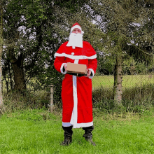 a man dressed as santa claus holding a box