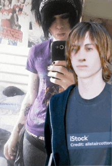 a man taking a selfie with another man wearing an istock t-shirt