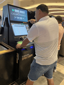 a man standing in front of a caesars sportsbook kiosk