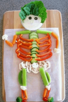 a skeleton made out of vegetables on a wooden board