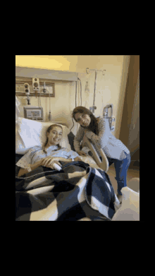 two women are standing next to each other in a hospital bed