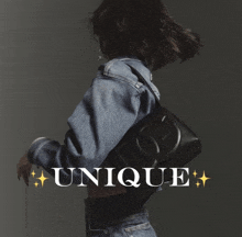 a woman in a denim jacket is holding a black purse and the word unique is on the bottom