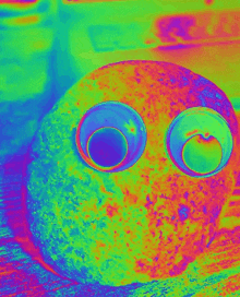 a colorful image of a rock with googly eyes on it .