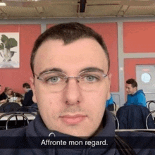 a man wearing glasses is taking a selfie in a restaurant with the caption affrotte mon regard