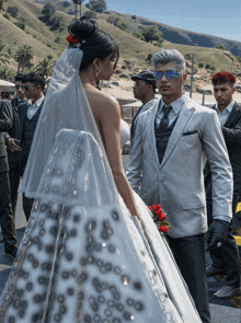 a man in a white suit stands next to a bride in a white wedding dress