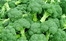 a bunch of broccoli heads are sitting on top of each other on a table .