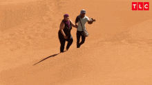 a man and a woman are walking down a sand dune with the words oh my god you 're lazy