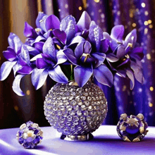 purple flowers in a vase with crystals on it