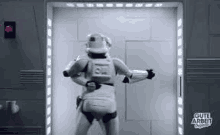 a storm trooper is standing in a doorway in a room .