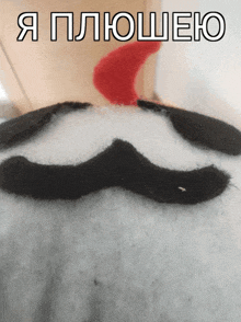 a close up of a stuffed animal with a mustache and the words " я плюшею "