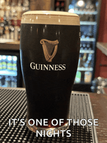 a glass of guinness beer sits on a bar