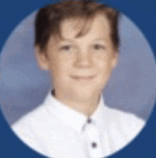 a young boy is wearing a white shirt and smiling in a circle .