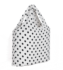 a white bag with black polka dots has a handle