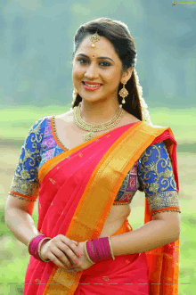 a woman in a red and orange saree with a blue blouse