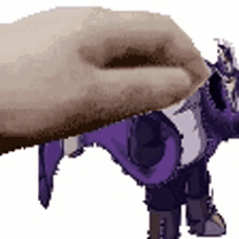 a hand is holding a purple and white elephant .