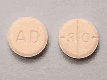 a close up of two pills with the letters ad on them .