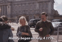 a man and a woman are standing in front of a building with the words history began on july 4 1776