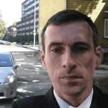 a man in a suit is standing in front of a building