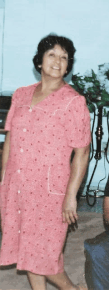 a woman in a pink polka dot dress is smiling for the camera