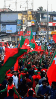 a crowd of people holding red and green flags in front of a building that says ' apollo ' on it