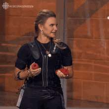 a woman is holding a pair of red dumbbells in front of a glass wall with the words #cbcdragonsden above her