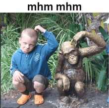 a boy squatting next to a statue of a chimpanzee with the words mhm mhm above him